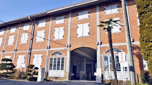 a brick building with a palm tree in front of it at Toyoko Inn Takasaki eki Nishi guchi No 2 in Takasaki