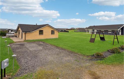 a yard with a house and a swing at Three-Bedroom Holiday Home In Vinderup in Vinderup