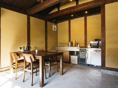 a kitchen with a table and chairs and a refrigerator at RITA Izumo Sagiura in Izumo