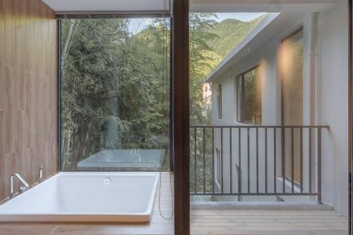 a bath tub on the balcony of a house at Vretreats yunxishang Boutique Hotel in Deqing