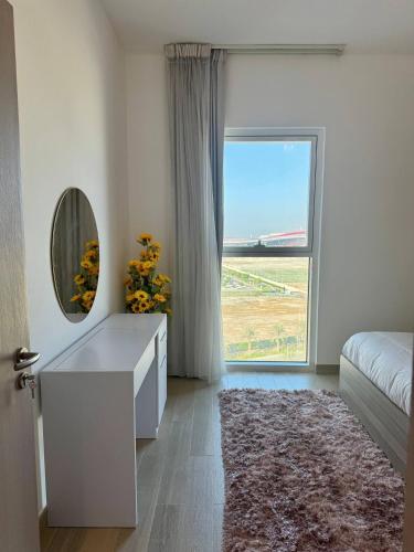 a bedroom with a large window and a dresser with a mirror at Canal & Marina View 1br High Floor Pool & Gym in Abu Dhabi