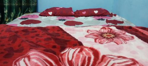 a bed with a floral blanket and pillows on it at Cena Homestay in Rejeng