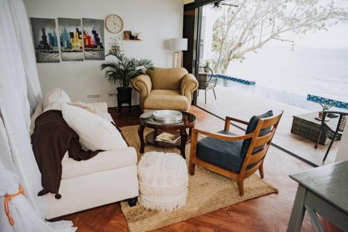 a living room with a white couch and a table at The French Villa-Santander Cebu in Santander