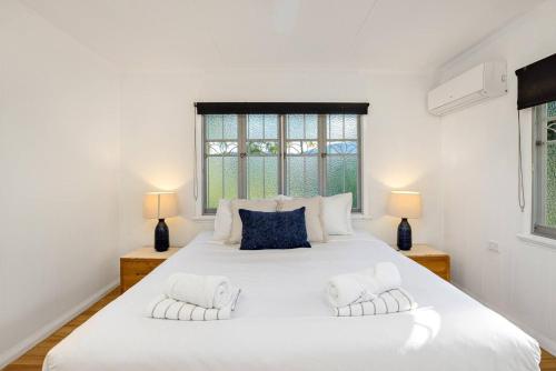 Cairns Northにある'Palm Paradise' Garden Getaway near Cairnsの大きな白いベッドと2つのランプのある寝室