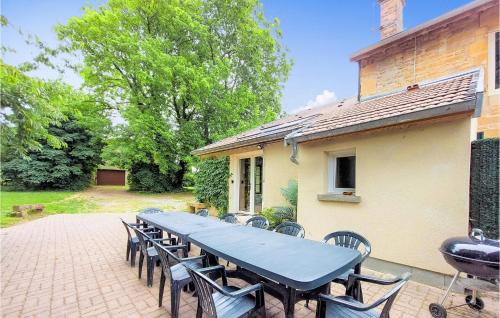 une grande table et des chaises sur la terrasse dans l'établissement Pet Friendly Home In Boult-Aux-Bois, à Boult-aux-Bois