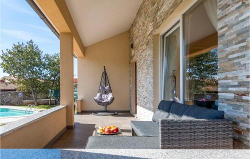 a patio with a couch and a table with a bowl of fruit at Two-Bedroom Holiday Home In Vodnjan in Vodnjan