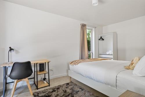 a bedroom with a bed and a desk and a chair at Tokenburg Townhouse in Launceston