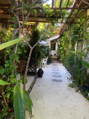 a garden with a pergola and a table and chairs at La Luna Boutique Dhangethi in Dhangethi