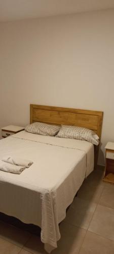 a bedroom with a large bed with a wooden headboard at Edificio San Lorenzo in Corrientes
