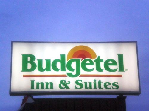 a sign for a building with a buldigerim and suites at Budgetel Inn & Suites Atlantic City in Galloway