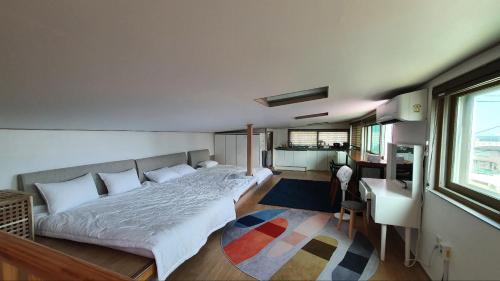 a bedroom with a bed and a desk and a window at Donghae ocean house in Donghae