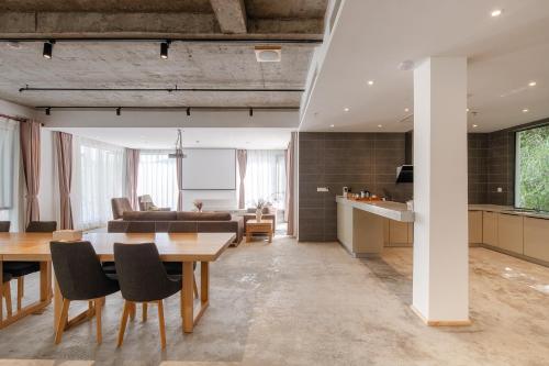 a kitchen and living room with a table and chairs at Vretreats yunxishang Boutique Hotel in Deqing