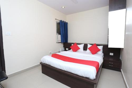 a bedroom with a bed with red pillows at Super Collection O R K International Near Gautam Buddha Park in Lucknow