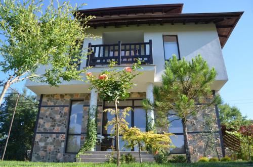 a house with windows and trees in front of it at Zapovedni Rai in Primorsko
