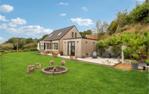 a barn style house with a fire pit in the yard at Cozy Home In Fredericia With Wifi in Fredericia