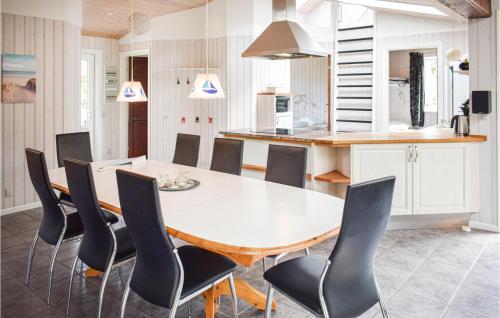 a kitchen and dining room with a white table and chairs at Holiday Home Lyngvej Tranekær Ii in Hou