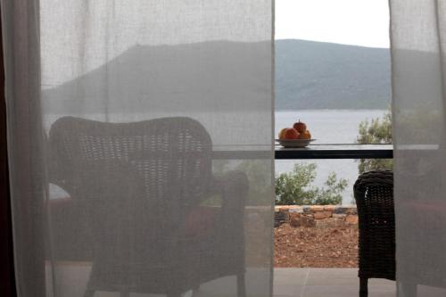 Steni Vala AlonissosにあるCasa Kalypso Suites & Villaの窓からテーブルと椅子の景色を望めます。
