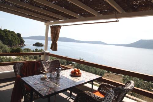 Steni Vala AlonissosにあるCasa Kalypso Suites & Villaのテーブルと椅子、水辺の景色を望むバルコニー
