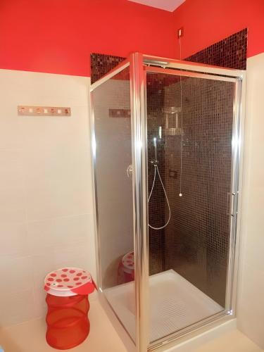 a shower in a bathroom with a red wall at Le Petit Monde - Eleganza e relax in centro a Abano Terme in Abano Terme