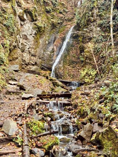 a waterfall on the side of a rocky mountain at Buddy House Borjomi in Borjomi