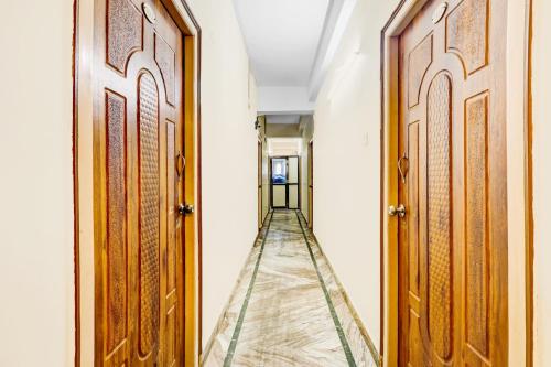 a corridor with two wooden doors and a long aisle at Super Hotel O Adarsh Nagar Near Kavya Hospital in Visakhapatnam