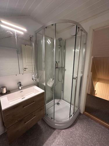 a bathroom with a shower and a sink at Stor hybel in Tromsø