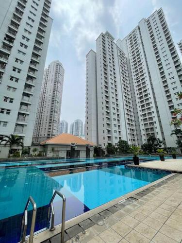 a swimming pool in front of some tall buildings at Newly Renovated 2BR Apt and Direct Mall Access in Jakarta