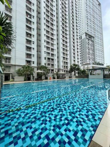 a large swimming pool in front of tall buildings at Newly Renovated 2BR Apt and Direct Mall Access in Jakarta