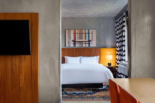 a hotel room with a bed and a television at The LOOM Hotel, Tapestry Collection by Hilton in Warwick