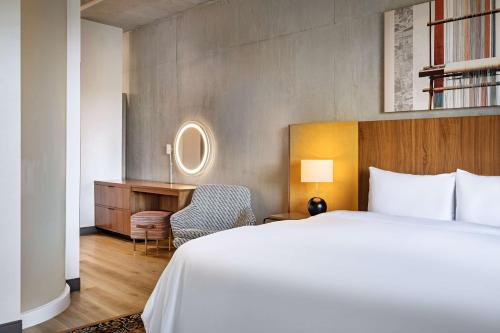 a hotel room with a bed and a desk at The LOOM Hotel, Tapestry Collection by Hilton in Warwick