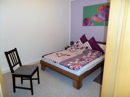 a small bedroom with a bed and a chair at Elbflair in Zahna-Elster