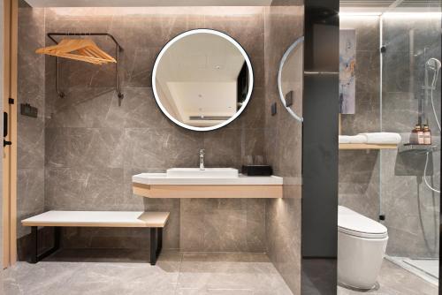 a bathroom with a sink and a mirror at Wenchang Meilin Holiday Hotel in Wenchang