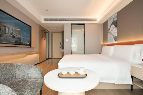 a hotel room with a bed and a table at Wenchang Meilin Holiday Hotel in Wenchang