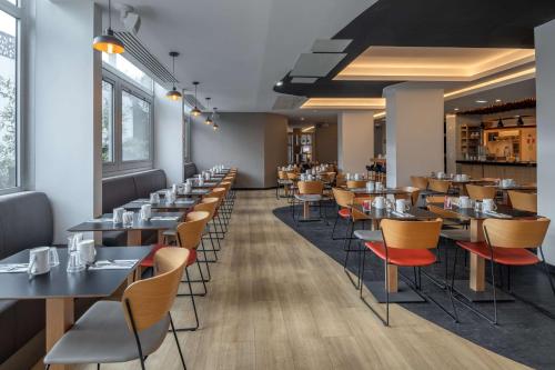 a row of tables and chairs in a restaurant at DoubleTree by Hilton Paris Bougival in Bougival
