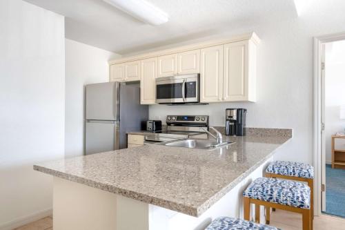 a kitchen with white cabinets and a granite counter top at Hilton Vacation Club The Cove on Ormond Beach in Ormond Beach