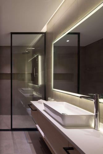 a bathroom with two sinks and a large mirror at Park Inn by Radisson Hotel & Apartments Kuwait in Kuwait