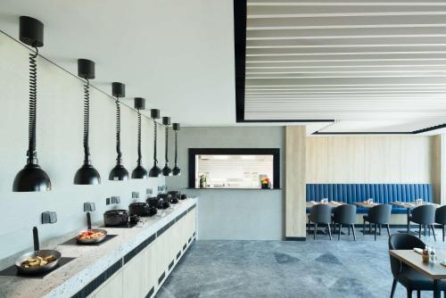 a dining room with tables and chairs and a counter sidx sidx sidx at Park Inn by Radisson Hotel & Apartments Kuwait in Kuwait