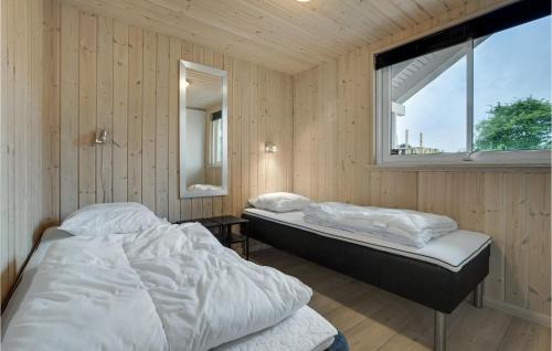two beds in a wooden room with a window at Amazing Home In Sydals With Sauna in Høruphav