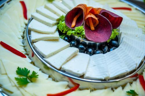 a plate of food with cheese and vegetables on it at Hotel Parc Sibiu in Sibiu