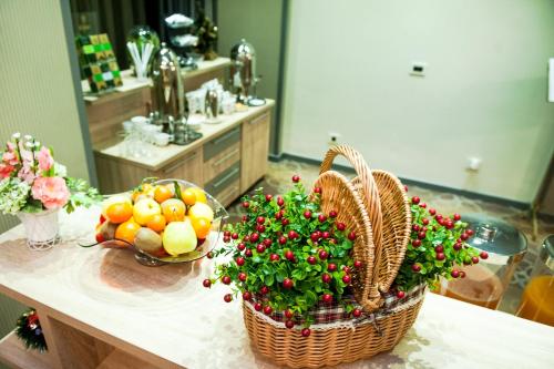 a counter with two baskets of fruit and flowers on it at Hotel Parc Sibiu in Sibiu