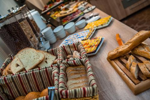 a table topped with lots of different types of bread at Hotel Parc Sibiu in Sibiu