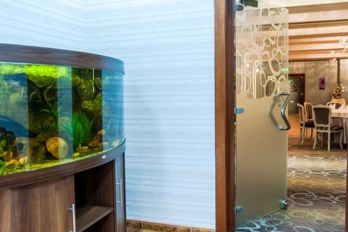 a fish tank next to a wall with a table at Hotel Parc Sibiu in Sibiu
