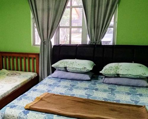 カンパン・パダン・マセラティにあるHomestay Langkawi Airportの枕が2つ付いたベッドと窓のある寝室