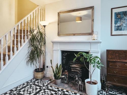 a living room with plants and a fireplace at St Clements Guesthouse in Oxford