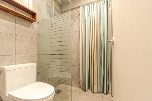a bathroom with a toilet and a shower at Jeju Stayra in Jeju