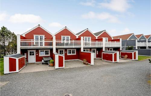 a large red house with white trim at Three-Bedroom Holiday Home In Blavand in Blåvand
