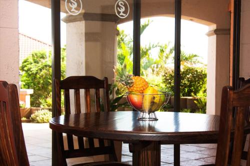 a bowl of fruit sitting on a wooden table at Stephan's Guest House in Port Shepstone