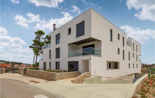 a white house on the side of a street at Stunning Apartment In Mali Losinj in Mali Lošinj