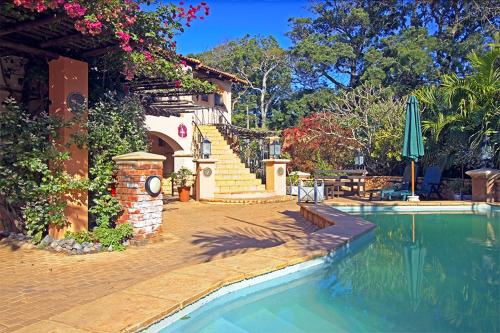 a house with a swimming pool next to a house at Stephan's Guest House in Port Shepstone