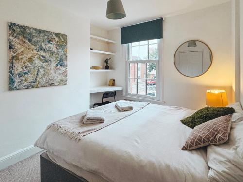 a bedroom with a large bed with a mirror at St Clements Guesthouse in Oxford
